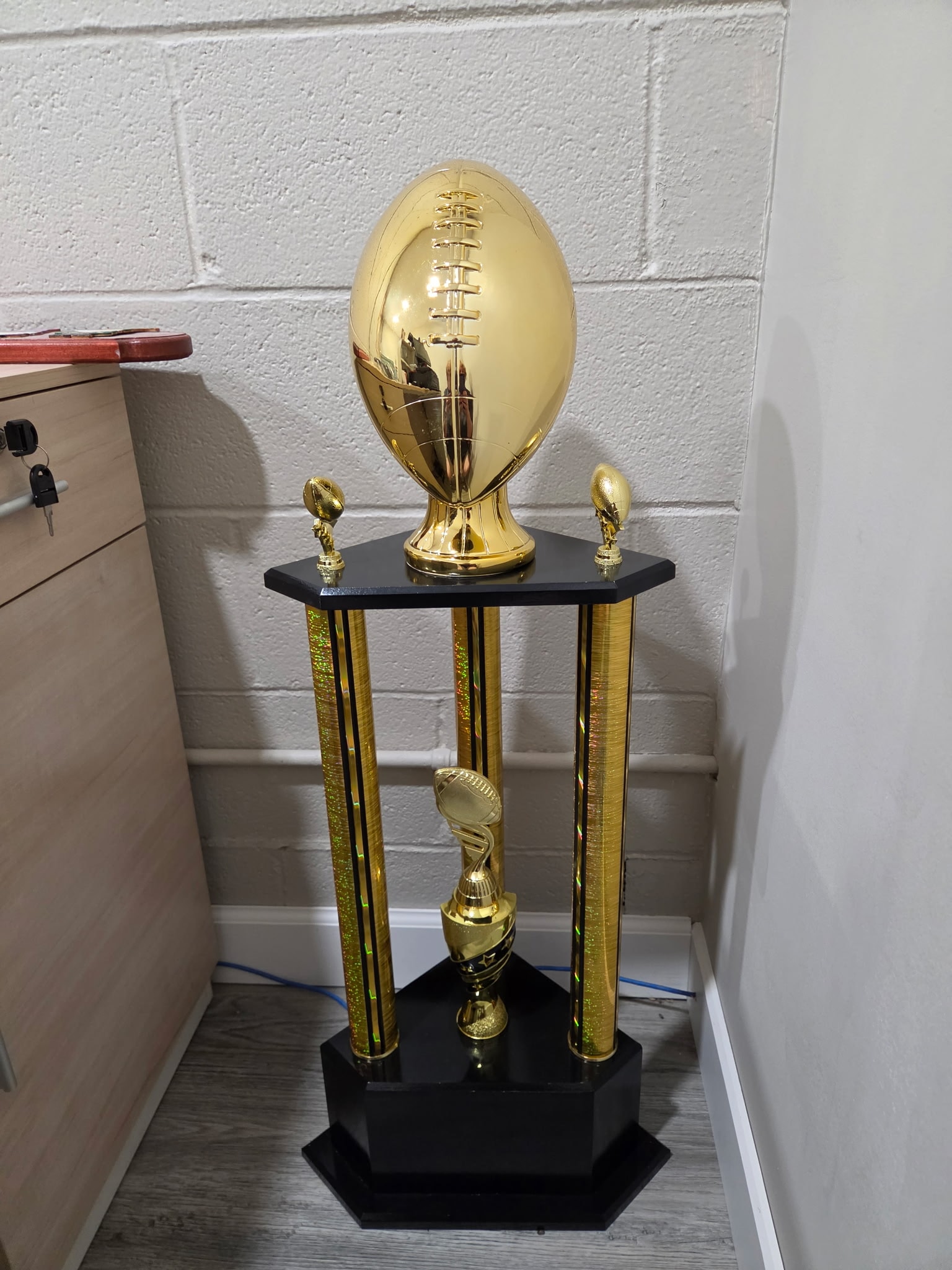 Large gold fantasy football championship trophy with black column base